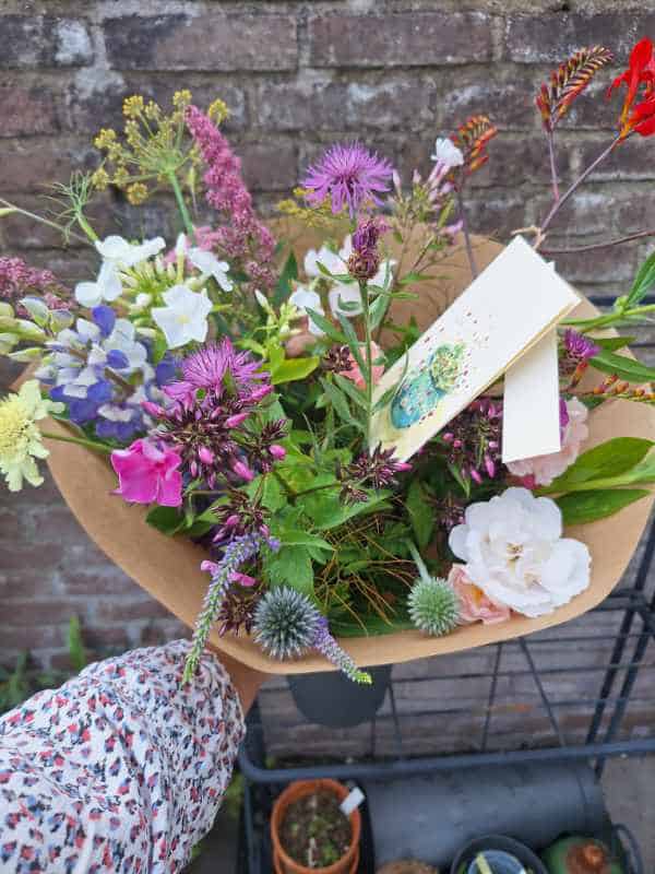 Biologisch boeket van het begin van de zomer, met papier en een wenskaart.